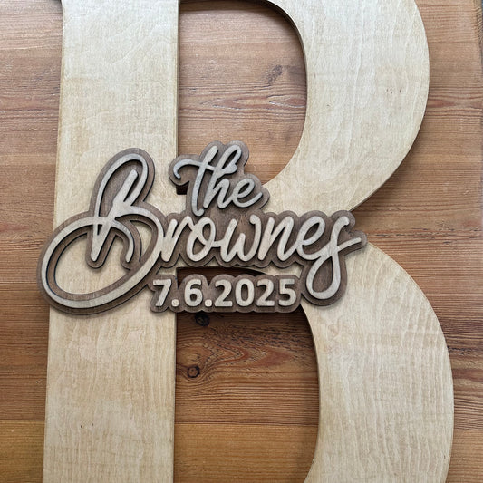 Close-up of a natural wood guestbook letter “B” featuring layered 3D engraving with “The Brownes – 7.6.2025.”