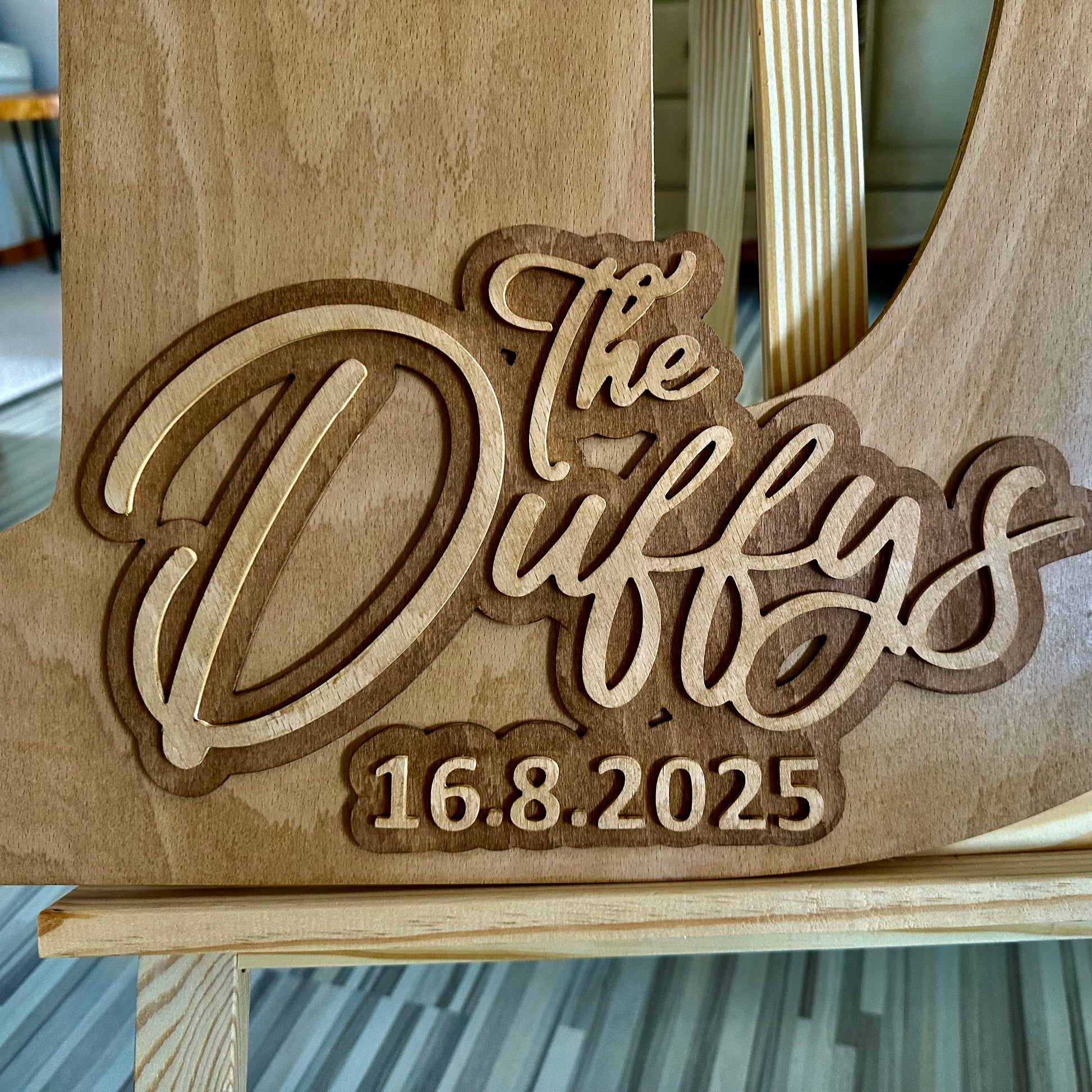 Layered wooden guestbook letter “D” with raised engraving of “The Duffys – 16.8.2025” in a bold, script-style design.