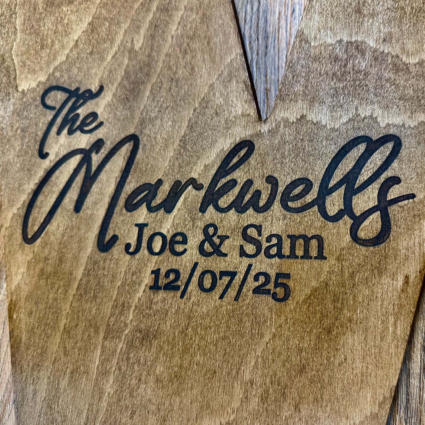 Laser-engraved wooden letter “M” with “The Markwells – Joe & Sam – 12/07/25” showcasing modern script and serif fonts.
