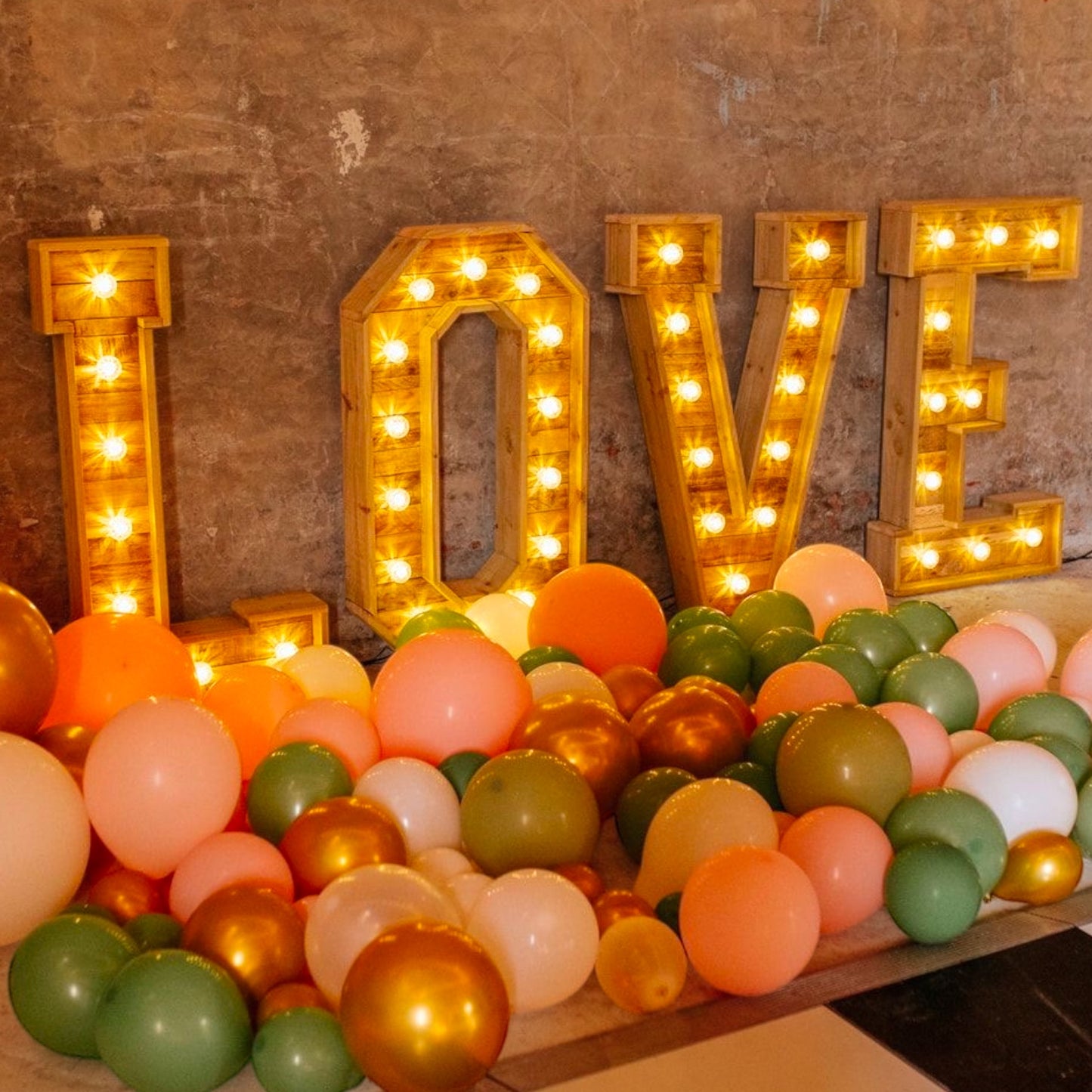 Glowing LOVE letters surrounded by colourful balloons — perfect for weddings or parties.